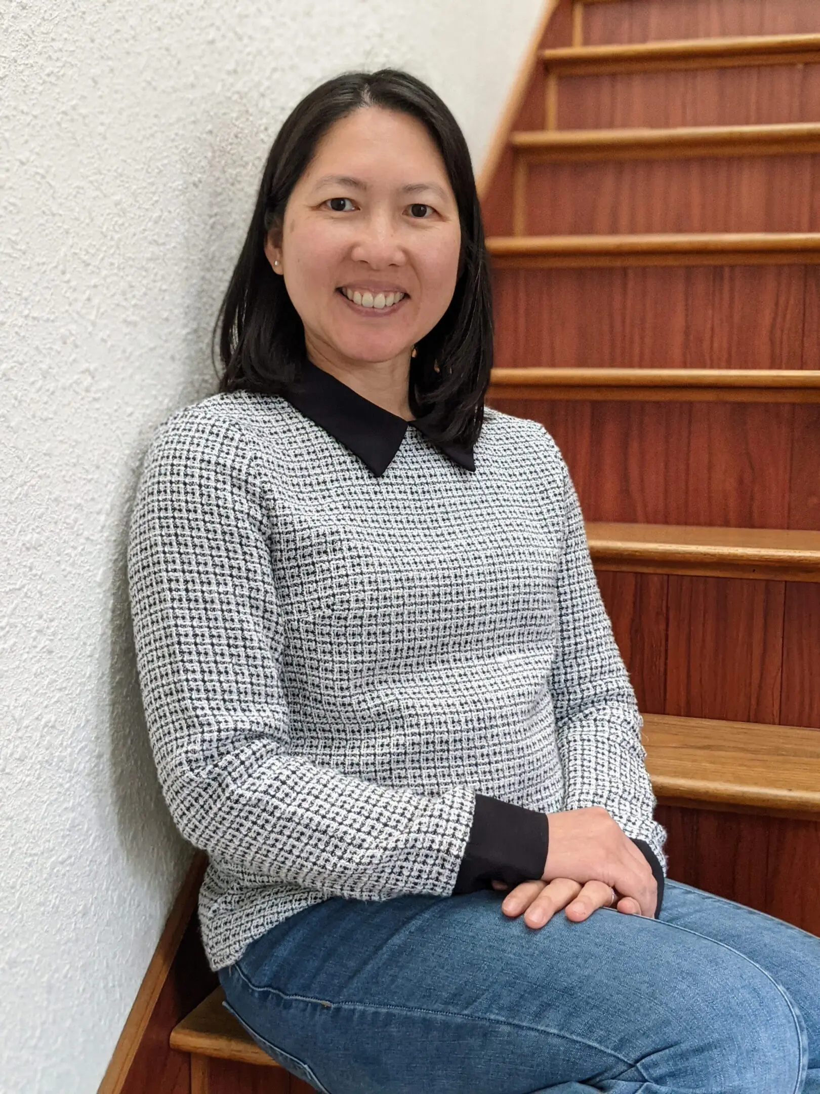 dr vu A woman sitting on top of steps in front of a wall.